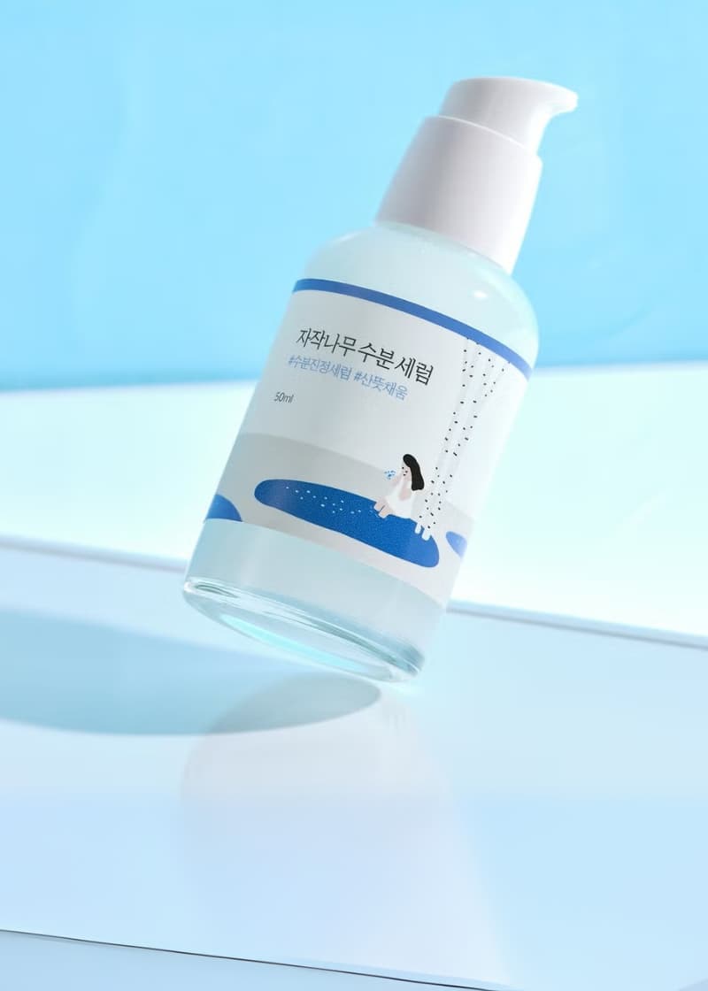 round lab birch juice serum bottle with pump on light blue background