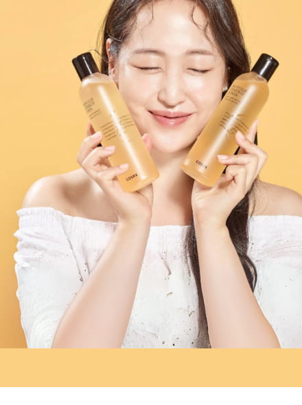 woman holding two cosrx propolis toner bottles