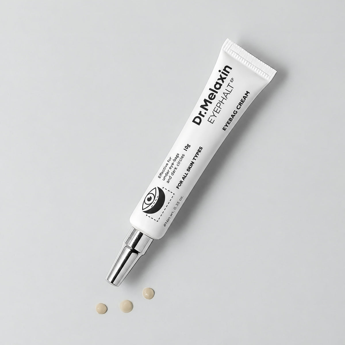A white tube of Dr. Melaxin Eyepalt eyebag placed diagonally on a light gray background with three small beige cream droplets below it.